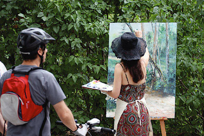 Un ciclista observa la obra de una de las participantes.